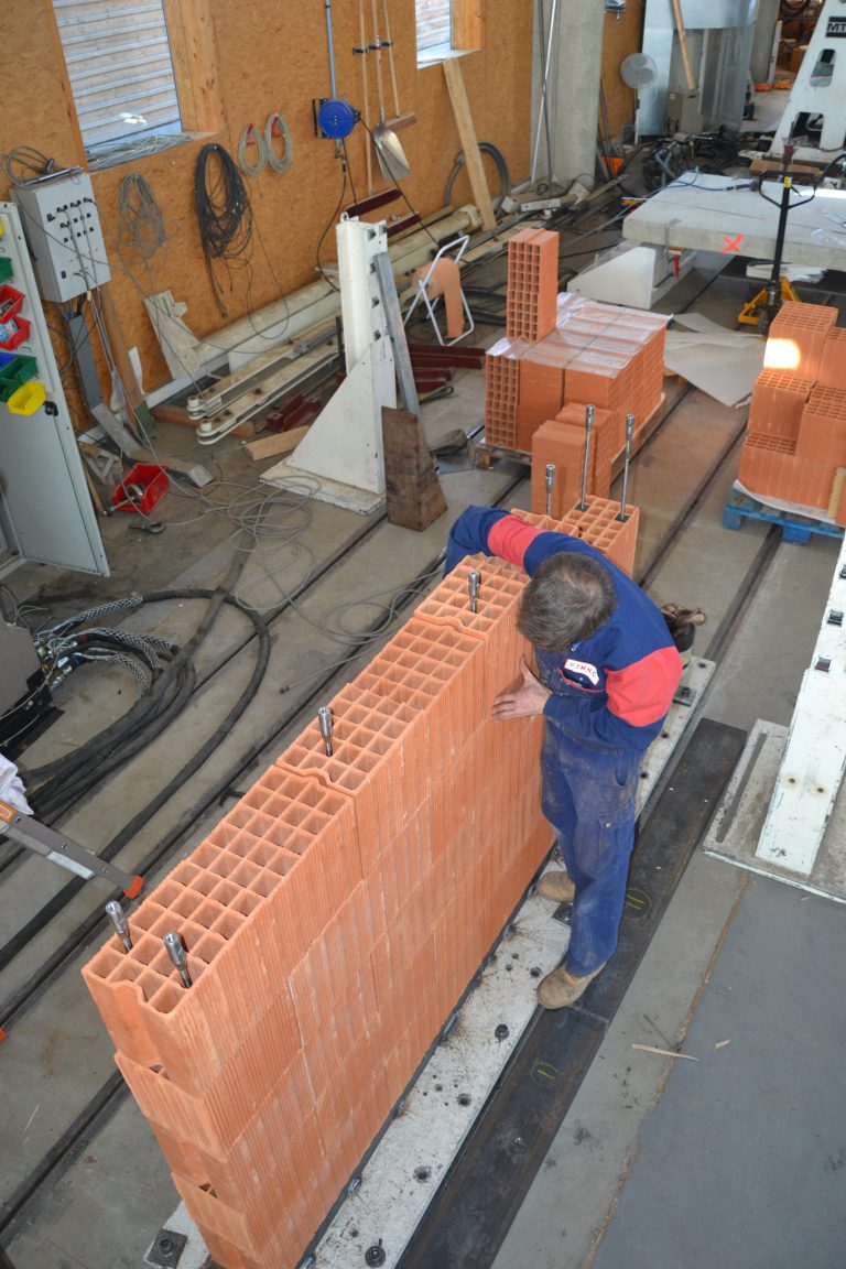 Montage d'un mur en briques de terre cuite avec tirants acier, réalisé au CTMNC